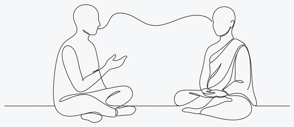 A person sitting on the floor talking with a hand raised, and a monk sitting opposite, upright and still.